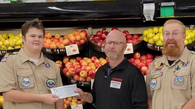 Michael Umthun and Scoutmaster Rick Dawson accepting a check from Fareway manager Matt Shannon